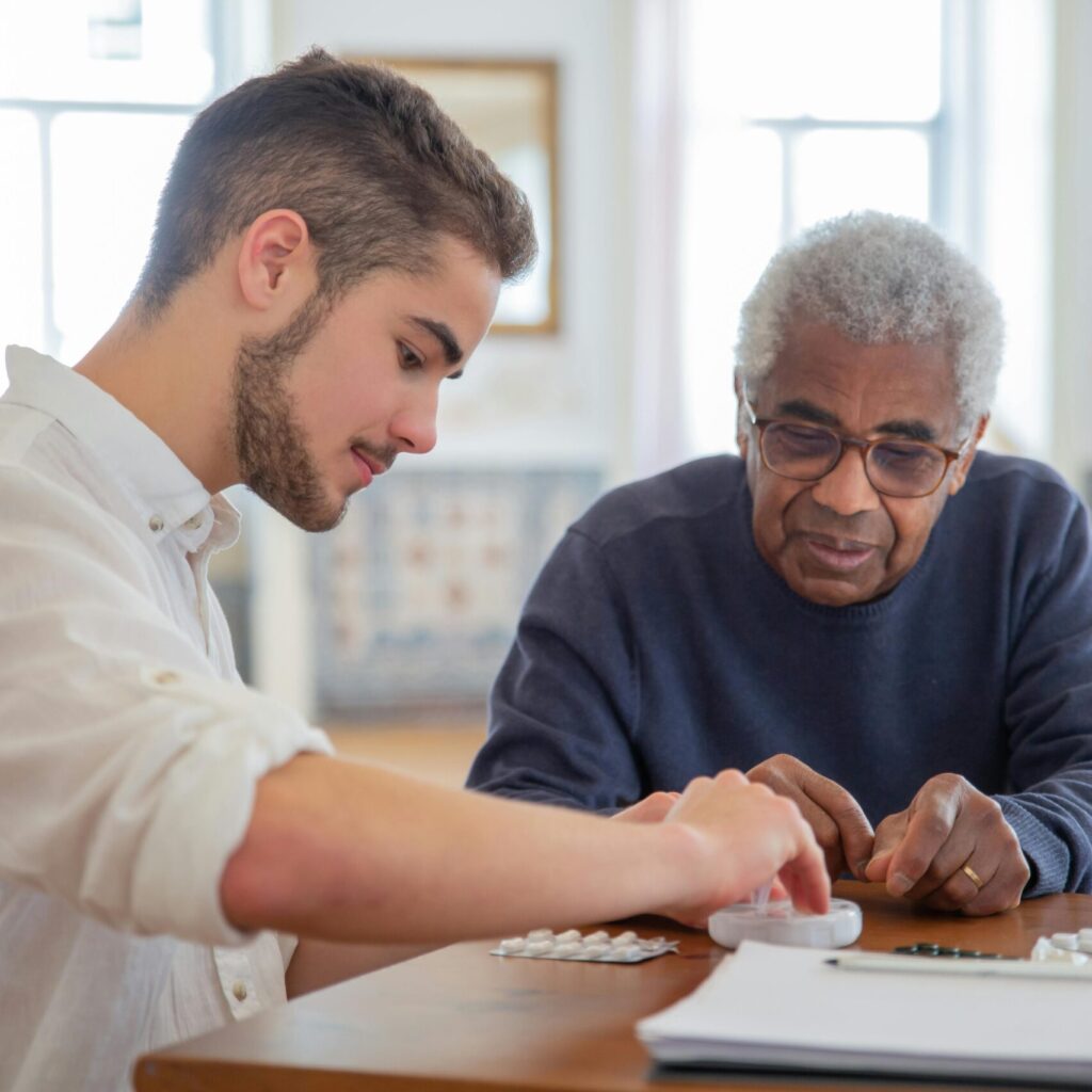 Ein junger und älterer Mann sortieren Tabletten