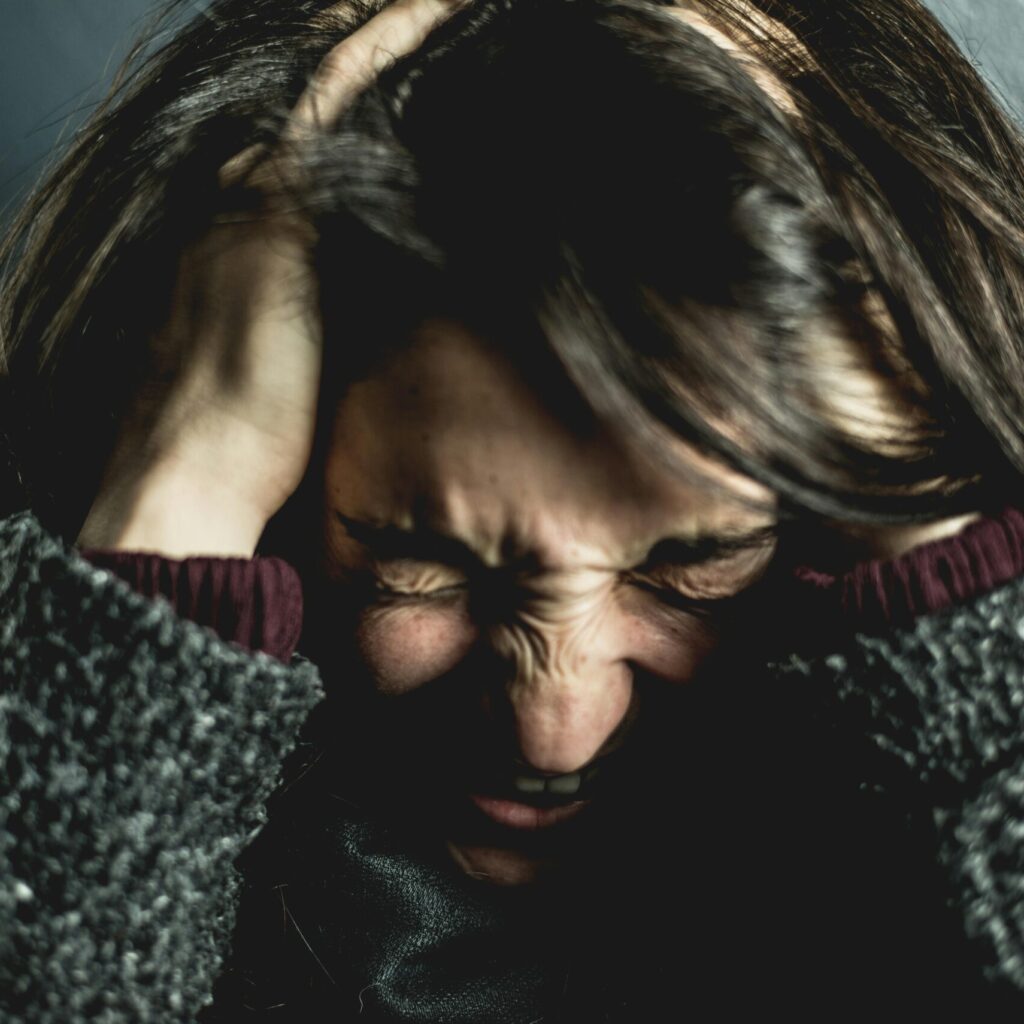 Nahaufnahme einer Frau, die sich in die Haare greift und schreit.